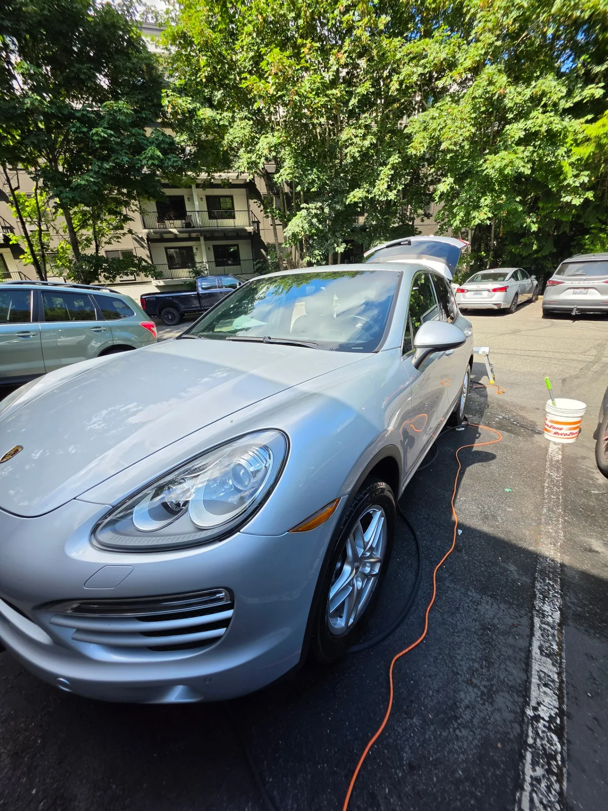 Silver Porsche Cayenne luxury SUV side profile during mobile detailing